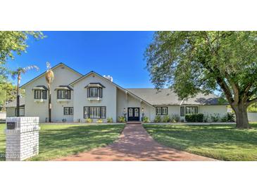 Beautiful two-story home with brick walkway, mature landscaping, and a white painted brick exterior at 1712 E Fairfield St, Mesa, AZ 85203