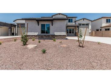 Charming two-story home featuring desert landscaping and a stone-accented facade at 17322 W Puget Ave, Waddell, AZ 85355