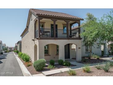 Charming two-story home featuring a balcony, landscaped front yard, and a covered entryway, offering curb appeal at 1799 N 209Th Ave, Buckeye, AZ 85396