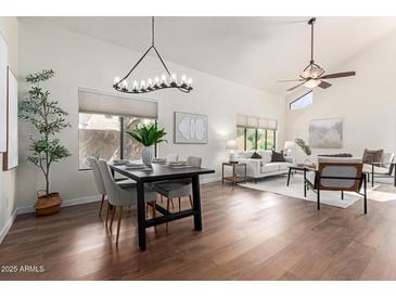 Bright open-concept living and dining area featuring wood floors and modern chandelier at 2635 N El Dorado Pl, Chandler, AZ 85224