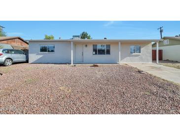 Charming single-story home featuring a low-maintenance front yard with rock landscaping and a covered entry at 2823 W Banff Ln, Phoenix, AZ 85053