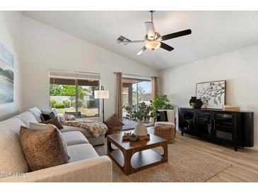 Cozy living room bathed in natural light features vaulted ceilings, a ceiling fan, and a comfortable sectional sofa at 810 E Potter Dr, Phoenix, AZ 85024