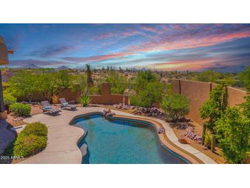 Inviting pool with lounge chairs surrounded by desert landscaping, offering a serene outdoor oasis at 8154 E Tecolote Cir, Scottsdale, AZ 85266