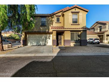 Two story home featuring a two-car garage and desert landscaping at 9415 W Eaton Rd, Phoenix, AZ 85037