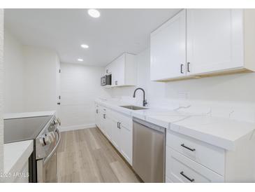 Bright kitchen featuring white cabinets, stainless steel appliances, and quartz countertops at 948 S Alma School Rd # 1, Mesa, AZ 85210
