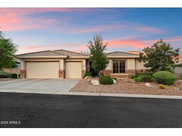 Well-maintained home featuring a three-car garage and manicured front yard with desert landscaping elements at 11193 N 121St Way, Scottsdale, AZ 85259