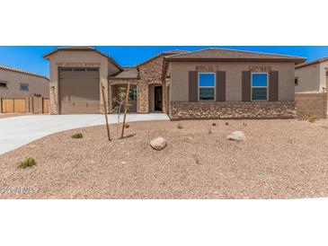 Charming single-story home with stone accents, desert landscaping, and a spacious three-car garage at 17308 W Royal Palm Rd, Waddell, AZ 85355