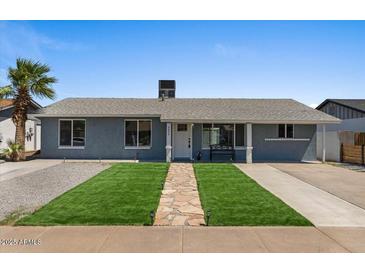 Charming single story home with manicured front yard, stone walkway and bench by front door at 2036 W Windrose Dr, Phoenix, AZ 85029