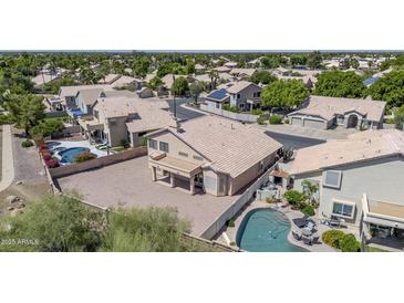 Aerial view of a tan home showing the pool and covered patio of this well manicured lot at 22019 N 59Th Dr, Glendale, AZ 85310