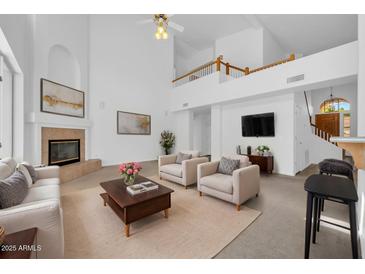 Bright living room boasts high ceilings, a fireplace, and ample seating for entertaining at 22019 N 59Th Dr, Glendale, AZ 85310