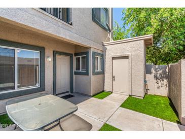 Charming townhome entrance with a small yard, featuring a table and updated neutral paint at 2311 E Hartford Ave # 29, Phoenix, AZ 85022