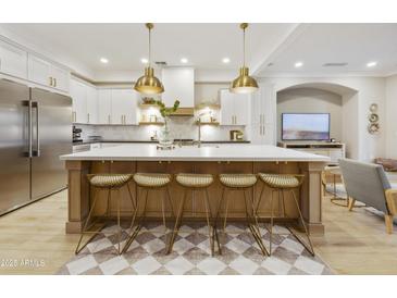 Stunning kitchen with white cabinetry, a large island with seating, and pendant lighting fixtures at 2501 S Roanoke St, Gilbert, AZ 85295