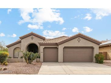 Charming single-story home with a tile roof, three-car garage, and desert landscaping at 40614 N Harbour Town Ct, Anthem, AZ 85086
