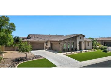 Beautiful single-Gathering home showcasing a well-manicured lawn and a three-car garage at 6917 E Ingram Cir, Mesa, AZ 85207