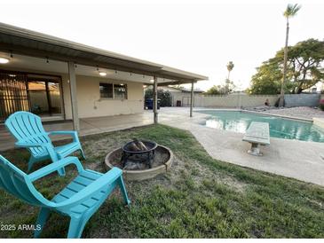 Inviting backyard with a fire pit, swimming pool, covered patio, and lounge chairs at 9615 N 34Th Ave, Phoenix, AZ 85051