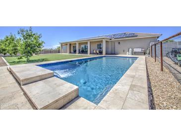 Inviting backyard oasis with refreshing pool, waterfall feature, and ample space for outdoor entertaining at 9759 E Brown Rd, Mesa, AZ 85207