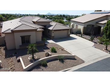 A charming home boasting a desert landscape, neutral colors, and a spacious three-car driveway at 2122 N Stapley Dr, Mesa, AZ 85203