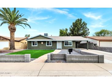 Charming single-story home with a well-manicured lawn and a classic desert landscape in a sunny, residential neighborhood at 3825 E Captain Dreyfus Ave, Phoenix, AZ 85032
