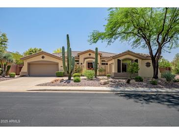 Inviting single-story home featuring beautiful desert landscaping and a charming tile roof at 41903 N Golf Crest Rd, Anthem, AZ 85086