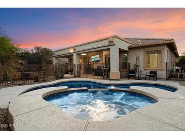 Backyard pool and covered patio with outdoor seating, perfect for relaxing or entertaining guests at 4413 W Phalen Dr, New River, AZ 85087