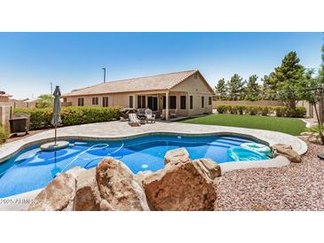 Backyard oasis featuring a sparkling pool, patio, and lush landscaping for outdoor enjoyment at 1583 N Constellation Ct, Gilbert, AZ 85234
