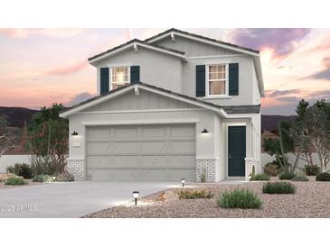 Charming two-story home with a two-car garage and desert landscaping at sunset at 17388 W Jessie Ln, Surprise, AZ 85387