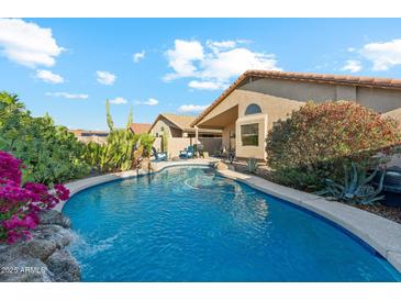 Inviting backyard pool with desert landscaping and a charming rock waterfall feature at 2432 W Oberlin Way, Phoenix, AZ 85085
