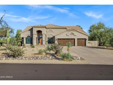Charming single-story home features a three-car garage and desert landscaping at 26475 N Wrangler Rd, Scottsdale, AZ 85255