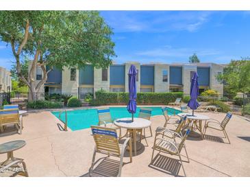 Community pool with outdoor seating in a well-maintained residential area with mature landscaping at 2946 N 14Th St # 37, Phoenix, AZ 85014