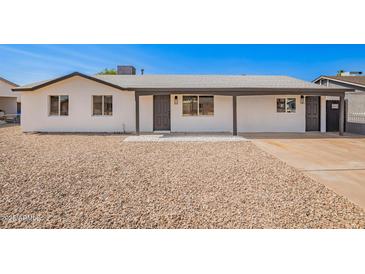 Charming single-story home with fresh white paint, gravel landscaping, and inviting covered entryway at 6140 W Berkeley Rd, Phoenix, AZ 85035