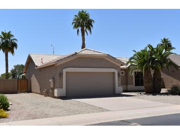 Charming single-story home featuring a two-car garage and desert landscaping with palm trees at 6460 S Springs Pl, Chandler, AZ 85249