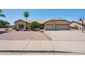 Charming home featuring low maintenance landscaping, tile roof, and a spacious three car garage at 6645 E Preston St, Mesa, AZ 85215