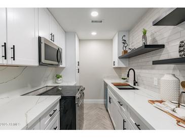 Bright and airy kitchen with white cabinets and stainless steel appliances at 1005 N Granite Reef Rd, Scottsdale, AZ 85257