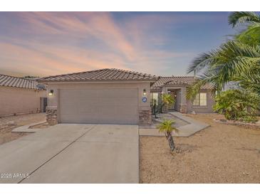 Charming single-story home featuring a two-car garage, desert landscaping, and a tile roof at 10305 E Dragoon Ave, Mesa, AZ 85208