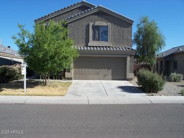 Charming two-story home featuring a two-car garage and well-maintained landscaping under a clear blue sky at 12550 W Lisbon Ln, El Mirage, AZ 85335
