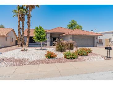 Charming single-story home featuring desert landscaping, a tile roof, and a two-car garage at 14420 N 44Th Dr, Glendale, AZ 85306