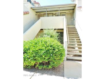 Condo exterior featuring a tidy garden, neutral colors, and easy access stairs at 30 E Brown Rd # 2113, Mesa, AZ 85201