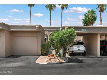 Charming single-story home with a one-car garage and a carport nestled beneath swaying palm trees at 4015 N 78Th St # 135, Scottsdale, AZ 85251