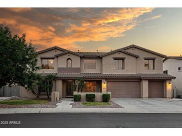 Gorgeous two-story home featuring well manicured landscaping, a two car garage, and beautiful desert sunset skies at 7156 S Forest Ave, Gilbert, AZ 85298
