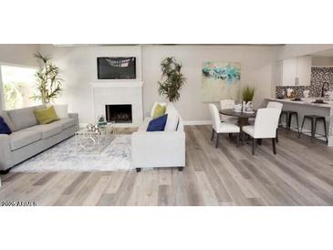 Bright, open living area with wood floors, fireplace, and neutral-colored furniture at 7840 N 7Th St # 15, Phoenix, AZ 85020