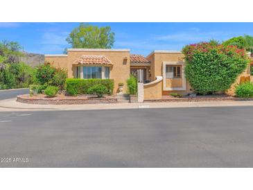 Charming home featuring well-manicured landscaping and a welcoming facade with colorful flowers enhancing its curb appeal at 1040 E Clinton St, Phoenix, AZ 85020