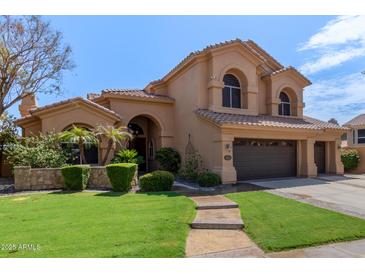 Charming home boasts a tile roof, lush landscaping, and a two-car garage at 1211 E Desert Flower Ln, Phoenix, AZ 85048
