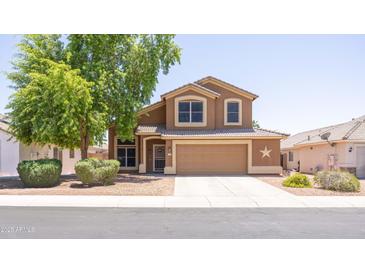 Two story home with a well maintained yard and a two car garage, featuring a decorative star at 12933 W Monterey Way, Avondale, AZ 85392