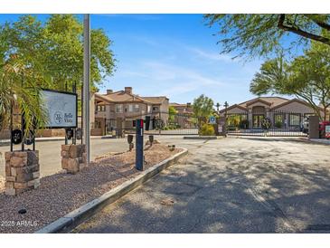 Gated community entrance featuring desert landscaping and well-maintained buildings under a clear blue sky at 14000 N 94Th St # 3198, Scottsdale, AZ 85260