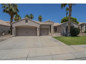 Inviting single-story home featuring a three-car garage, desert landscaping, and charming curb appeal at 1826 W Oriole Way, Chandler, AZ 85286