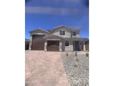 Charming two-story home showcasing a spacious three-car garage and a welcoming facade with manicured landscaping at 18778 E Panchito Dr, Gold Canyon, AZ 85118