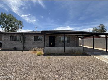 Single story home with a carport, gravel front yard, and block construction at 2007 W Roeser Rd, Phoenix, AZ 85041