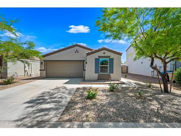 Charming single-story home with a well-manicured front yard, desert landscaping, and a two-car garage at 25657 W Beth Dr, Buckeye, AZ 85326