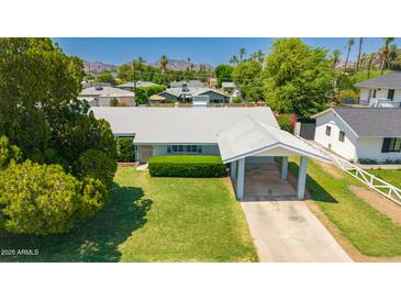 Charming single-story home with a well-maintained lawn and convenient covered parking at 4140 E Glenrosa Ave, Phoenix, AZ 85018