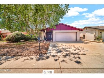 Traditional home featuring a two-car garage and mature landscaping in a suburban neighborhood at 5140 N 69Th Ave, Glendale, AZ 85303